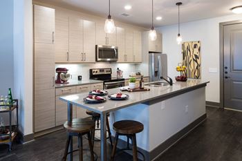 A kitchen with a table and chairs and a refrigerator.